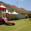 Parco giochi all'aperto con scivoli colorati e montagna sullo sfondo.
