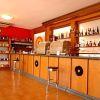 Interno di un bar con scaffali pieni di bottiglie e sgabelli di fronte al bancone.