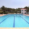 Una grande piscina all'aperto circondata da palme e lettini.