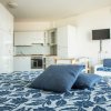 Interno moderno con letto, cucina e TV.