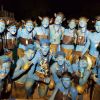 Persone truccate di blu in gruppo sorridono.