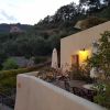 Terrazza con tavolini e sedie, circondata da natura.