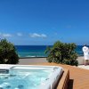 Terrazza con jacuzzi e vista mare, due persone in accappatoio.