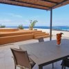 Terrazza con tavolo, sedie e vista mare.