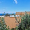 Terrazza con piante, vista mare e cielo azzurro.