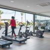 Palestra con attrezzature, persona su tapis roulant.