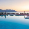 Piscina al tramonto con vista montagna e mare.