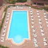 Piscina rettangolare vista dall'alto con sdraio bianche.