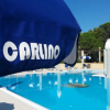 Una piscina con ombrelloni blu e bianchi.
