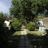 Vialetto con bungalow tra alberi e cespugli.