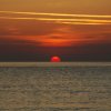 Tramonto sul mare con cielo arancione.