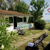 Casa con giardino, lettini blu e mare sullo sfondo.
