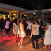 Gruppo di persone che ballano sulla pista illuminata di sera.