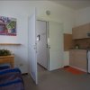 Cucina semplice con divano e porta aperta.