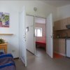 Sala con divano, cucina e vista su camera da letto.