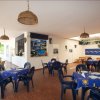 Ristorante con tavoli all'aperto e sedie di plastica.