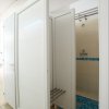 Doccia con piastrelle blu e porta bianca.