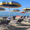 Spiaggia con ombrelloni gialloblù e lettini.