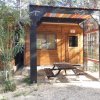 Struttura in legno con tavolo da picnic e tettoia.