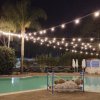 Piscina illuminata di sera con luci appese.