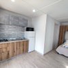 Monolocale con cucina moderna, frigorifero, microonde e letto matrimoniale con asciugamani.