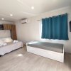 Camera con letto matrimoniale, divano letto singolo, tende blu e TV a parete.