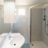 Bagno moderno con doccia, lavabo doppio e piccolo finestrino.