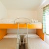 Camera con due letti singoli, uno a castello. Tende a righe e asciugamani sul letto inferiore.