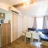 Cucina e sala da pranzo in stile moderno, con tavolo apparecchiato, divano e cucina compatta.