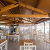 Un ristorante con tavoli e sedie bianche sotto un soffitto di legno.