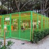 Un campo da gioco recintato con rete verde in un'area alberata.