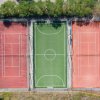 Veduta aerea di campi sportivi: due campi da tennis e uno da calcio.