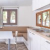 Cucina moderna con finestra, tavolo e divano angolare.