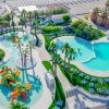Due piscine con giochi d'acqua colorati e lettini, vicino alla spiaggia.