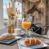 Colazione con croissant, succo d'arancia e caffè su un bancone vicino alla spiaggia.