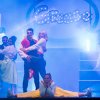 Persone che ballano sul palco con l'insegna 