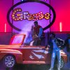 Scena di Grease con ragazzi e un'auto stilizzata.