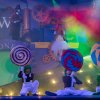 Attori con megadire lollipop e costumi da Oompa-Loompa su un palco colorato.