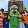 Personaggi in costume, inclusi Minnie e Pippo, posano felici all'aperto.