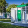 Complesso di suite moderne con facciate bianche e verdi, immerse nel verde.