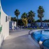 Una piscina con sdraio, palme e la scritta 