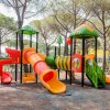 Parco giochi colorato con scivoli e altalene.