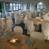 Sala da pranzo allestita con tavoli apparecchiati e candele.