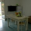 Soggiorno con tavolo, sedie e balcone aperto.