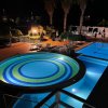 Piscina notturna con luci colorate.