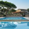 Piscina all'aperto vicina a un edificio e alberi.