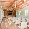 Sala conferenze con sedie bianche e travi in legno.