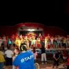 Persone su un palco che ballano di fronte a un pubblico.