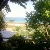 Vista sul mare attraverso alberi e fogliame.