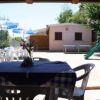 Tavolo coperto con tovaglia a quadretti, vista su cortile con casetta-gioco e scivolo.